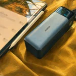 Powerbank Anker 737 z przewodem i tabletem podczas ładowania sprzętu.