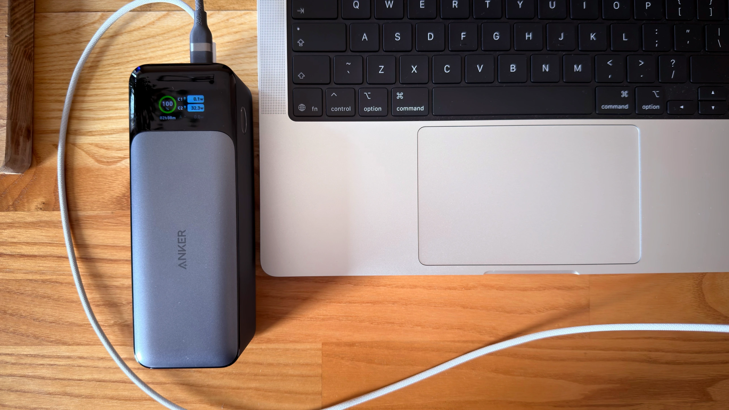 Powerbank Anker 737 ładuje laptopa na biurku.