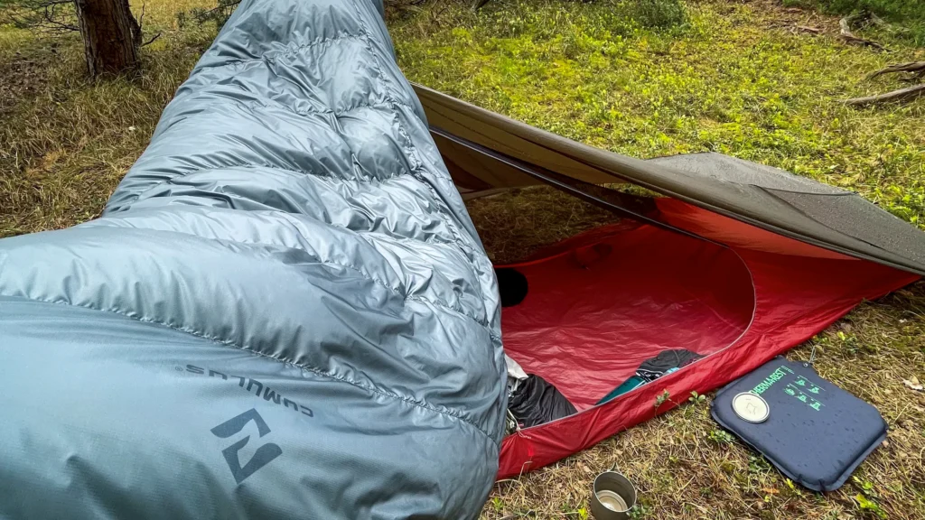 Quilt Cumulus rozłożony przy namiocie podczas biwaku.