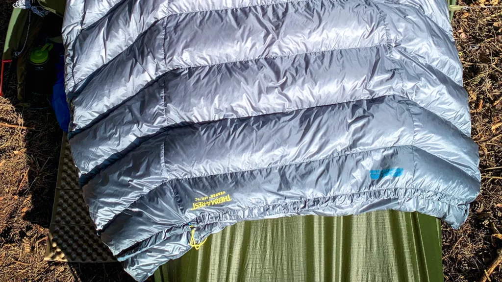 Quilt Therm-a-Rest Vesper rozłożony na namiocie podczas biwaku.